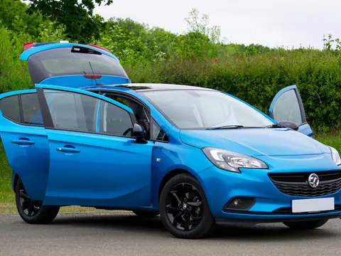 A blue hatchback with its doors and tailgate open