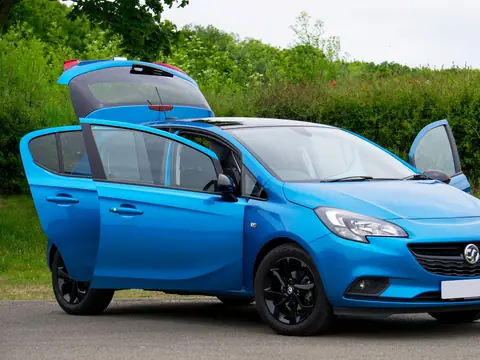 The rear side windows of a blue hatchback with its doors open